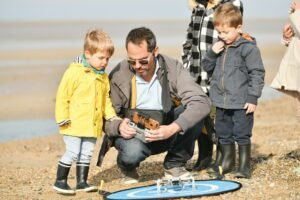 Father with children on a walk shows how the drone works